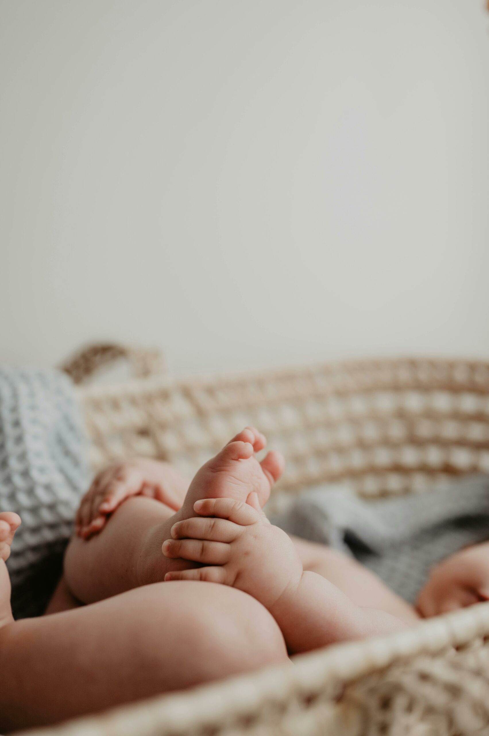 Close-up of baby feet in a soft basket, capturing innocence and fragility.